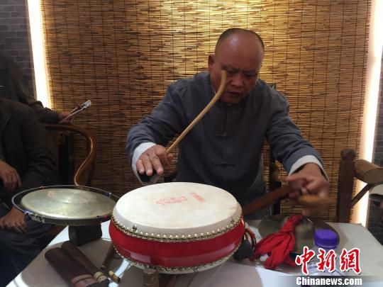 坐在中间的老艺人一边说唱,一边操作快板、书鼓、镲、响锣、木鱼、鼓、醒木、脚蹬梆、高音锣和塌音锣等11种乐器。图为盲人老艺人正在表演。 杨静 摄