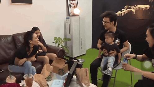 章子怡坐在沙发上，大女儿小苹果坐在一旁