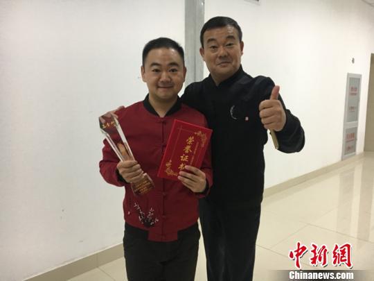 当晚的颁奖晚会上，张冰和搭档王晓武领取奖杯。 张冰供图