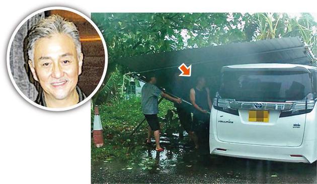 吴岱融(中)与邻居在强风下合力处理吹倒的棚架免伤及他人。