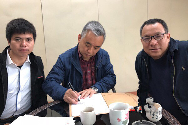 王跃文（中）与胡勇平（右）、刘凯（左）律师签署授权维权委托书