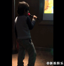 小黑发卡,表情专注地唱着歌,还时不时抖腿蹦跳,十分