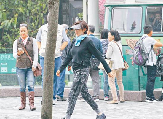 关之琳挺胸大步向前走,身材玲珑浮凸