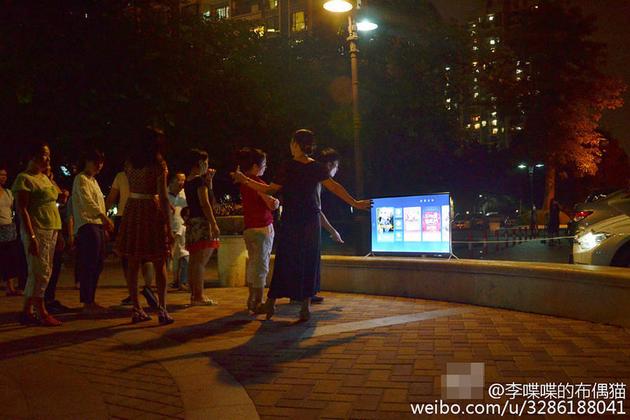 图为大妈们搬电视跳广场舞。