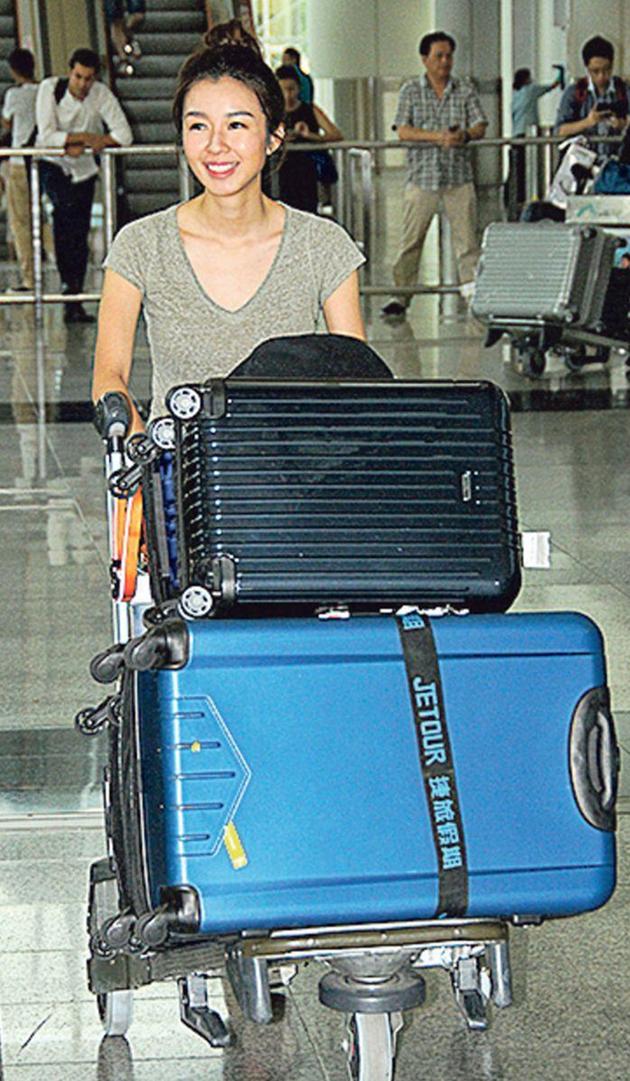 麦明诗26日从巴西回香港，一个人推着6件行李乘坐机铁回家。