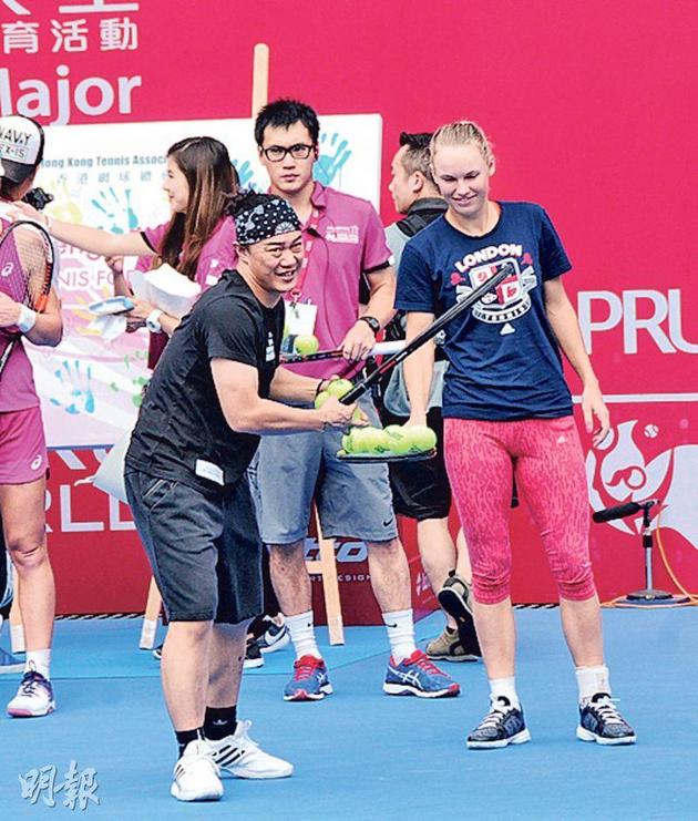 前网坛一姐卡洛琳·沃兹尼亚奇帮陈奕迅递网球。