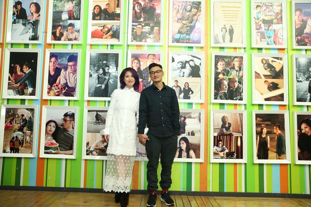 阿乐和千嬅在志明春娇照片墙前合影