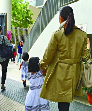 黎姿领着双胞胎女儿去学校。