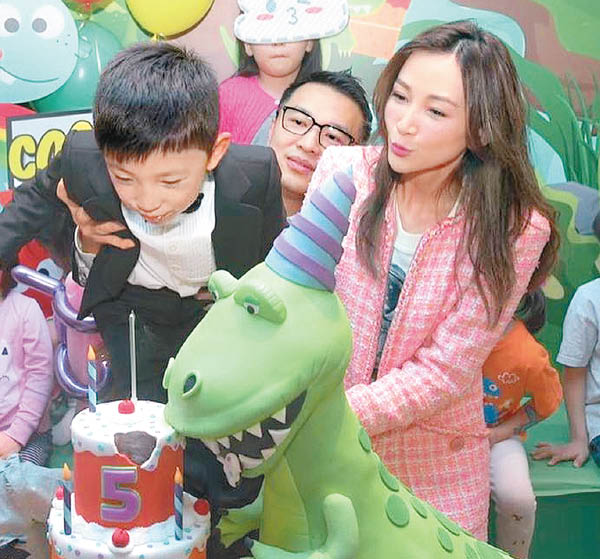 薛华韬吹蜡烛时被父亲从后抱着，诸葛紫岐甜笑。