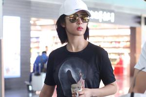 杨紫黑衣配红裤现身手捧保温杯