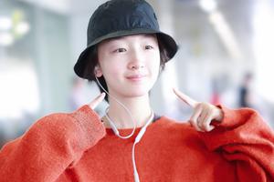 周冬雨双指点脸搞怪 套oversize毛衣摆臂前行