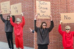 比伯与好友举牌宣传新专辑 红衣红裤发型不羁