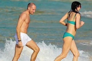 邓文迪与肌肉男海边戏水 穿绿色泳装身材发福