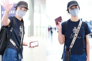 汤唯休闲装look现身北京机场 手持护照向粉丝挥手