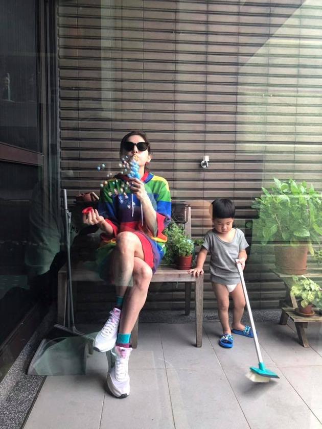 她儿子劲宝只穿著上衣和尿布入镜,乖巧地在一旁扫地。
