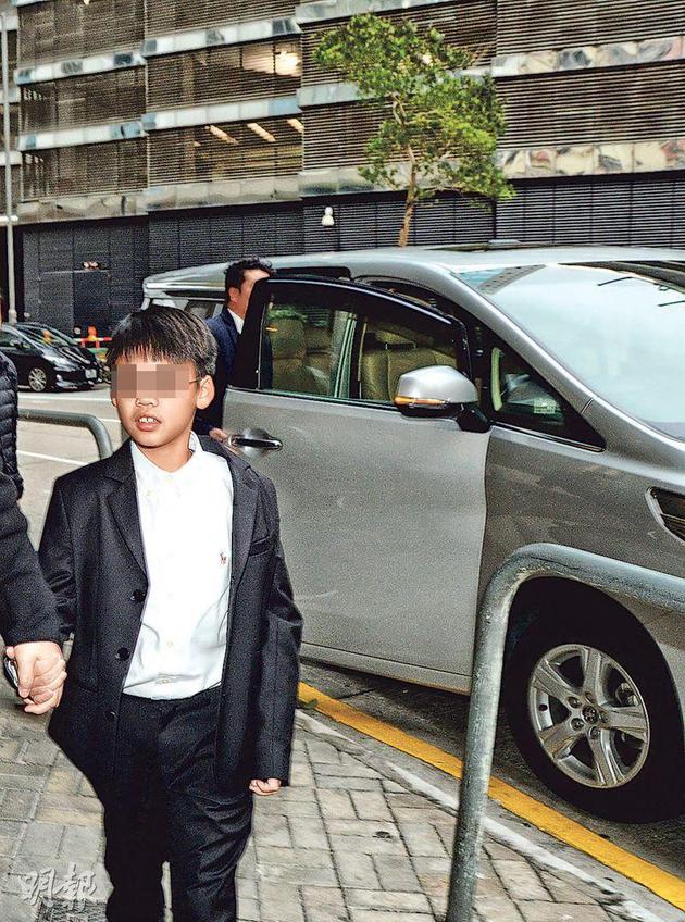 李嘉欣的7岁儿子许建彤,由助手陪同下抵达灵堂。