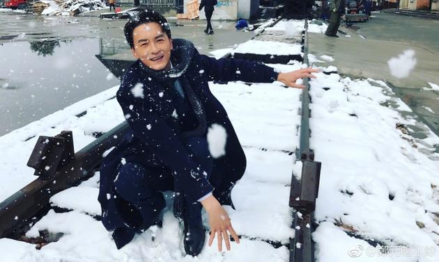 郑元畅街头玩雪笑容畅怀 轻抚栏杆半蹲心情超好