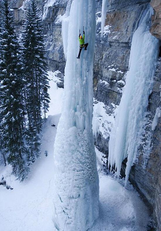 有眩晕感吗？呃，一位攀岩者用冰镐攀爬一条冰冻的瀑布。