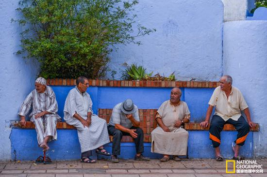 古城街头，有不少老人坐在街边的石凳上闲聊，不紧不慢，安然闲适。