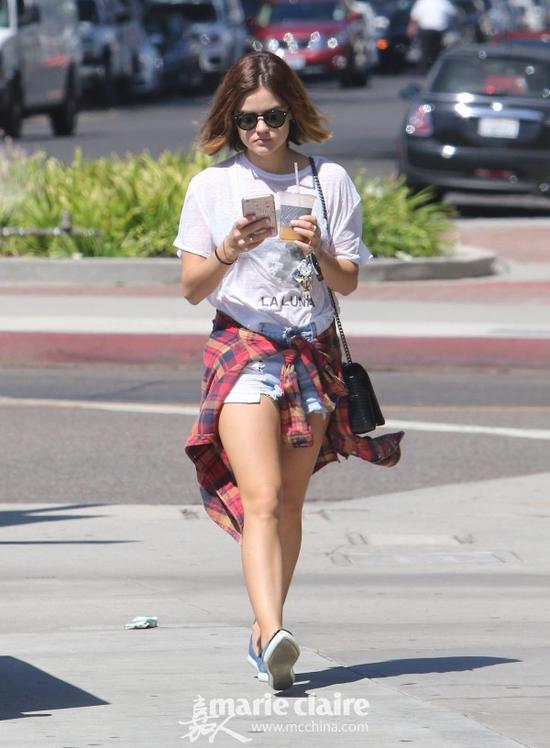露西·海尔(Lucy Hale)现身街头,她身穿白色字母印花T恤,肩挎黑色链条包,腰系红色格纹衬衫,下配破洞牛仔短裤,脚踩牛仔铆钉尖头懒人鞋。