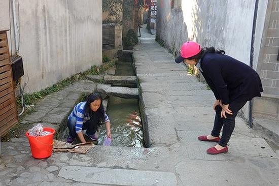 “你这能在河里洗衣服可真好！”一个游客感叹道，大姐回复说：“我想要台洗衣机。”