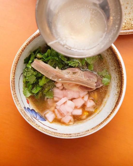 ▲ 在铺满调料的碗里,浇上一勺羊肉汤。 摄影/学文映像