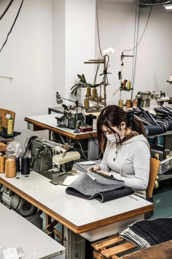 ■ 桃太郎的缝纫作坊内，工匠正在修补数十条客人送返的旧牛仔裤。