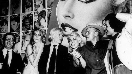 （从左到右）编辑 Bob Colacello ，模特 Jerry Hall，艺术家 Andy Warhol，歌星 Debbie Harry ，作家 Truman Capote，珠宝设计师 Paloma Picasso在 Studio 54 为 Interview 杂志举办派对