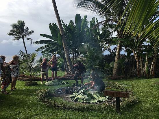 塔韦乌尼岛天堂度假村的服务人员在为客人烹制一道传统地蒸菜