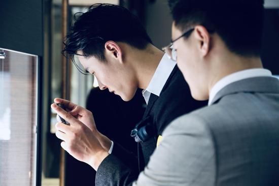 在唐利伟先生的介绍下,李振对珠宝和名表兴趣浓厚,拿出手机拍摄重点拍品