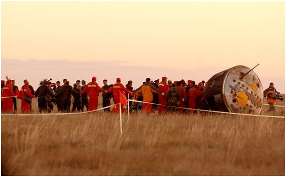 2003年10月15日9时，中国第一艘载人飞船神舟五号发射成功，中国首位航天员杨利伟成为浩瀚太空的第一位中国访客。图为2003年10月16日6时23分，神舟五号载人飞船在内蒙古主着陆场成功着陆，返回舱完好无损。新华社记者 张领 摄