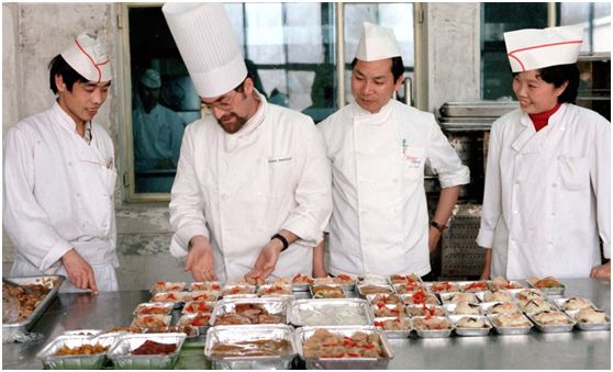 1980年4月10日，中国第一家中外合资企业——北京航空食品有限公司被批准成立。图为北京航空食品公司厨师长、法国人孟培沙（左二）和助理厨师长、香港同胞邓耀全（右二）等在一起研究航空菜肴的配制（1986年5月摄）。