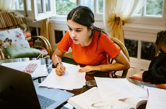 ■ 一个大学生正在她的笔记本电脑上做作业 / 盖蒂图片社（Carol Yepes）