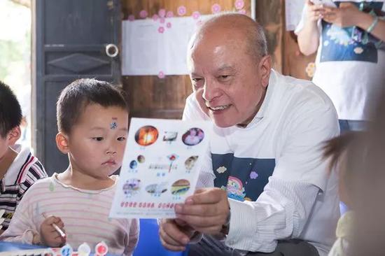 　中国发展研究基金会副理事长兼秘书长卢迈与“一村一园计划”受益儿童在一起