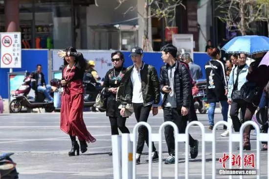 昆明街头穿着四季不同衣服的市民。 任东 摄
