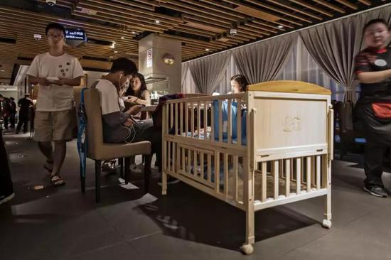 上海一家海底捞餐厅内,餐桌旁放了一个婴儿床