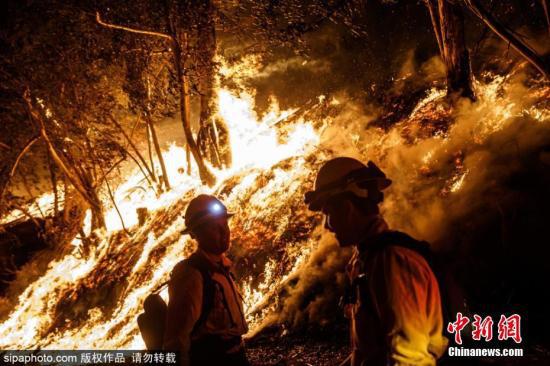 资料图：美国加州Somis地区发生山火，城市上空浓烟滚滚，消防员紧急灭火。图片来源：Sipaphoto 