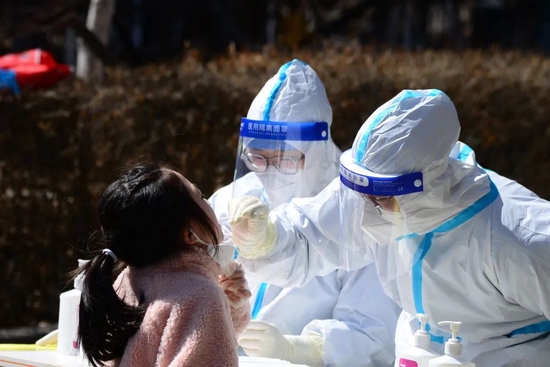 4月7日，在长春市南关区一处核酸检测点，医务人员为居民进行核酸采样。图源：新华社
