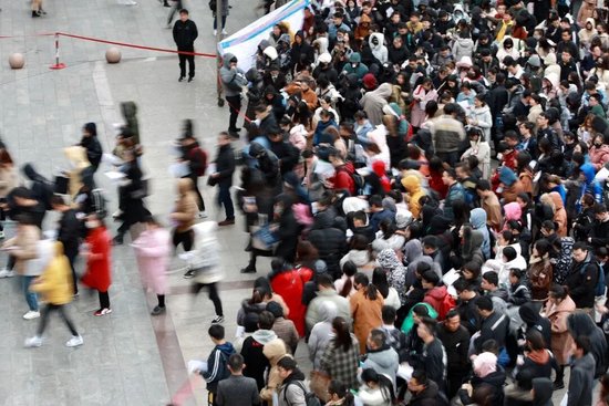  某国考考点，警戒线解除后考生大量涌入考场，大有“千军万马过独木桥”之势/图源：视觉中国