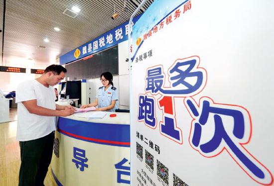 2018年6月12日,河北省魏县政务服务中心内的国税地税联合办税大厅,市民在咨询相关业务。图/新华