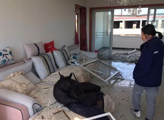 在爆炸地点附近，一些居民住宅房门窗严重受损，满地狼藉。摄影/本刊记者 胥大伟