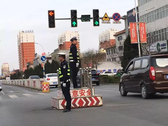 奥威路上车流缓动,交警在岗工作