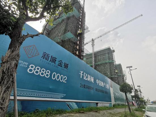 7月6日,新城金樾项目外的围墙上,“千亿新城 中国地产8强”的广告。