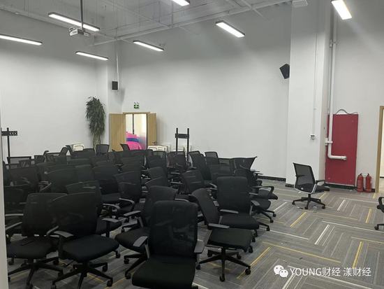 In the conference room on the first floor, chairs are being stacked together