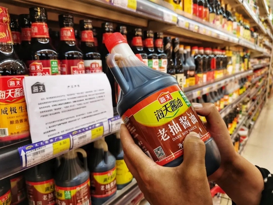 2022年10月5日，云南保山，在昌宁县的一个大型商超里，调味品专柜上张贴着海天味业的严正声明，市民如往常一样在选购海天酱油等调味品。（图|视觉中国）