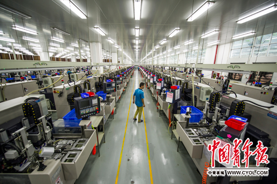 11月24日,东莞市寮步镇一家工厂车间内,一位工人在已经完成了“机器换人”的厂房内