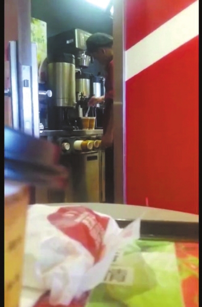 服务员将用过的勺子放进饮品中。网友视频截图