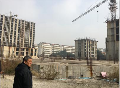 一位购房户惆怅地望着破落的燕山公馆“烂尾”工地。 代秀辉 摄