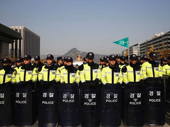 　韩国警方在通往青瓦台总统府的广场前加强了警力，以阻止抗议者冲向总统府区域。（新华/路透）