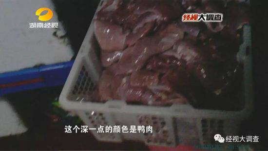 一位工人把去皮鸭大胸放入绞肉机中,把鸭肉打碎,掉到地上的鸭肉又被捡起来重新利用。